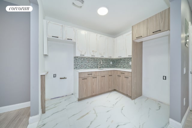 kitchen featuring sink, light brown cabinetry, and decorative backsplash