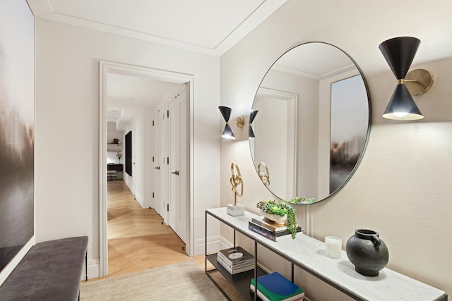 hall featuring baseboards, crown molding, and light wood-style floors