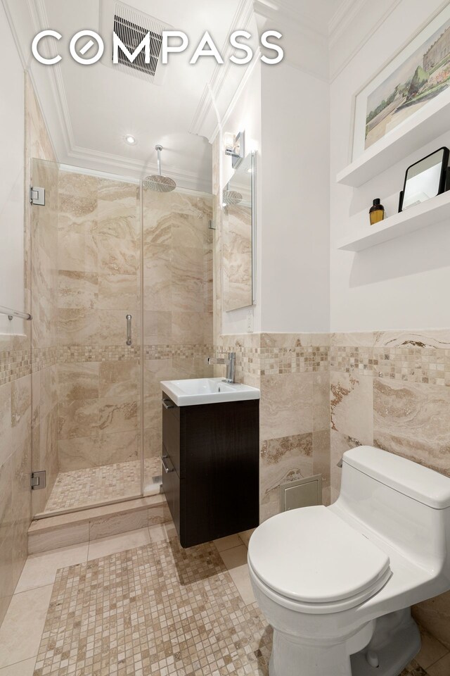 bathroom featuring tile walls, a shower with door, ornamental molding, and toilet