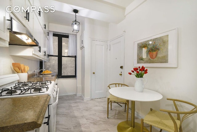 kitchen featuring decorative light fixtures, sink, white cabinets, decorative backsplash, and white range with gas stovetop