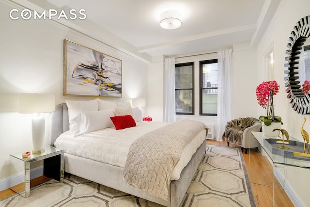 bedroom featuring light wood finished floors and baseboards