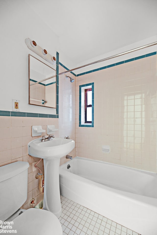 bathroom featuring toilet, tile patterned flooring, bathtub / shower combination, and tile walls