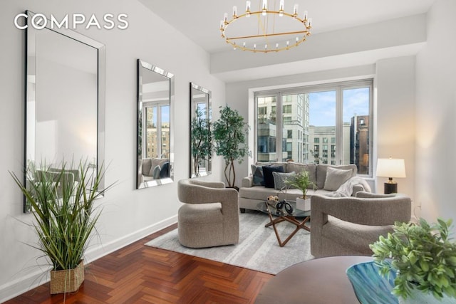 sitting room with a notable chandelier and baseboards