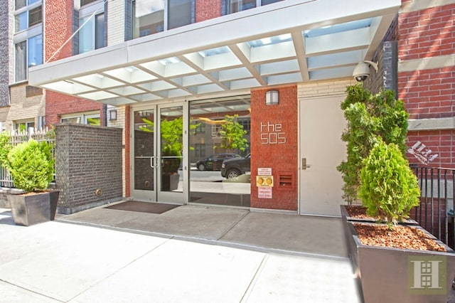 view of exterior entry featuring french doors and brick siding