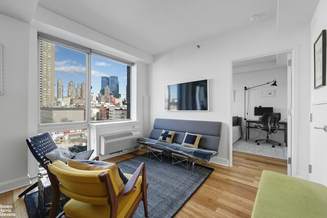 living room featuring wood-type flooring and a wall mounted AC