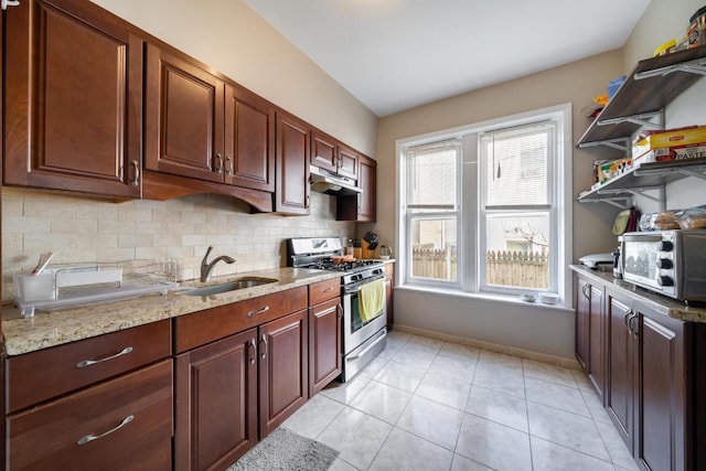 kitchen featuring light tile patterned flooring, sink, light stone counters, stainless steel range with gas cooktop, and decorative backsplash