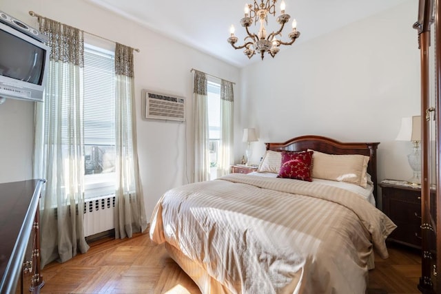 bedroom with a chandelier, light parquet flooring, a wall mounted AC, and radiator heating unit