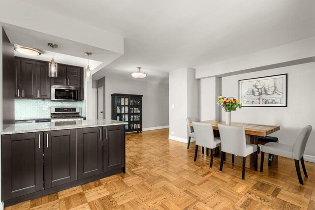 kitchen with tasteful backsplash, stainless steel appliances, decorative light fixtures, and dark brown cabinets