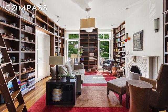 sitting room with a fireplace and wood finished floors