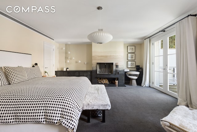 carpeted bedroom with a glass covered fireplace, french doors, and access to exterior