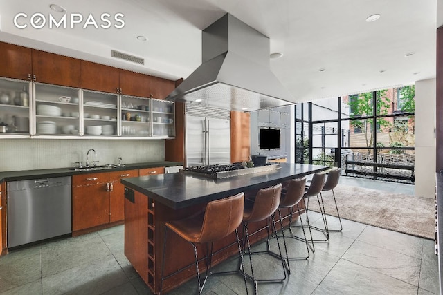 kitchen featuring tasteful backsplash, sink, a wall of windows, a center island, and stainless steel appliances