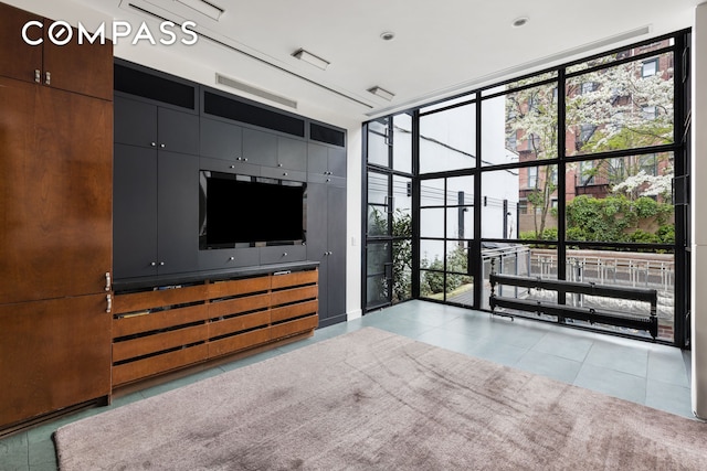 unfurnished living room featuring tile patterned floors, expansive windows, and visible vents