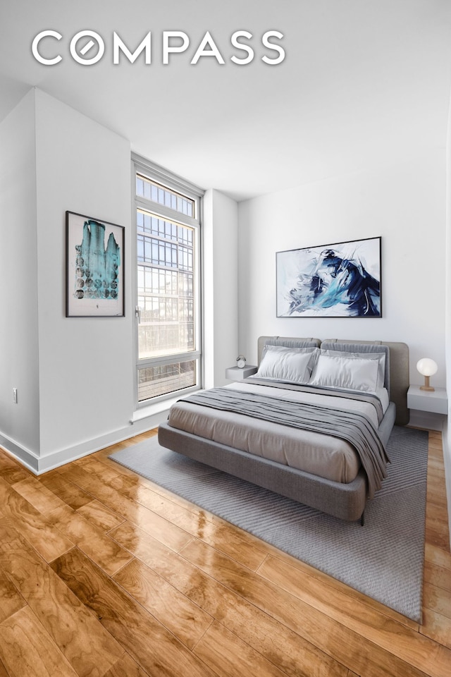 bedroom featuring wood finished floors and baseboards