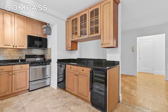 kitchen with baseboards, wine cooler, glass insert cabinets, black appliances, and backsplash