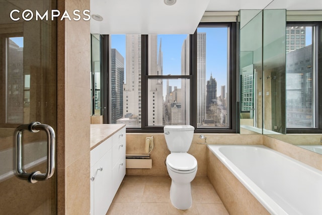 full bathroom featuring toilet, tile patterned floors, a garden tub, a view of city, and baseboard heating