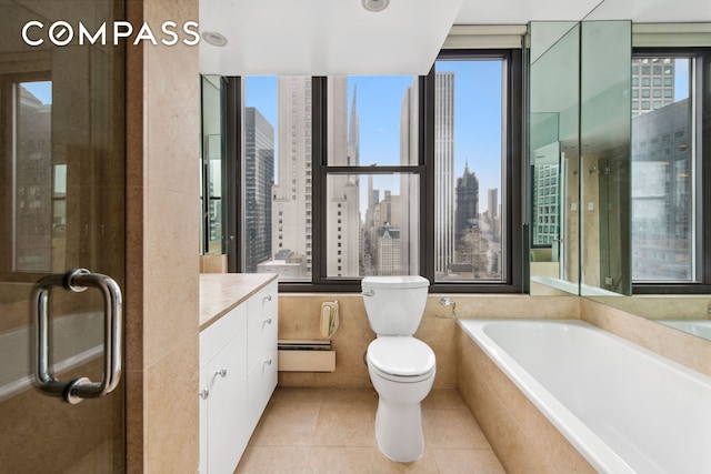 117 E 57th St Unit 35D, New York City, NY 10022 - bathroom with baseboard heating, vanity, a skyline view, a garden tub, and tile patterned flooring