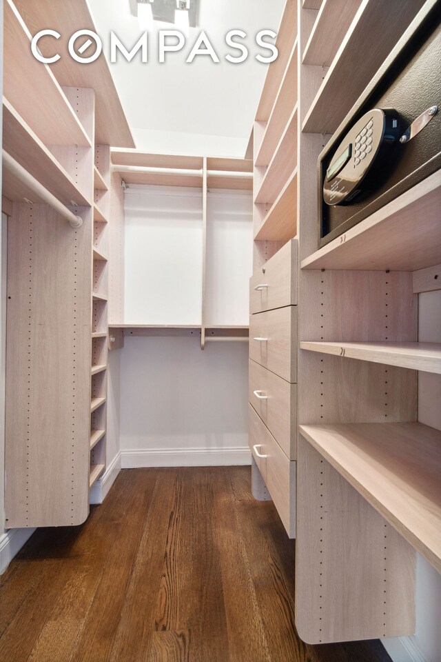 walk in closet with dark hardwood / wood-style flooring