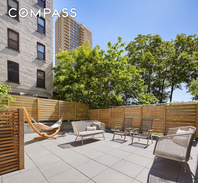 view of patio featuring an outdoor hangout area and fence