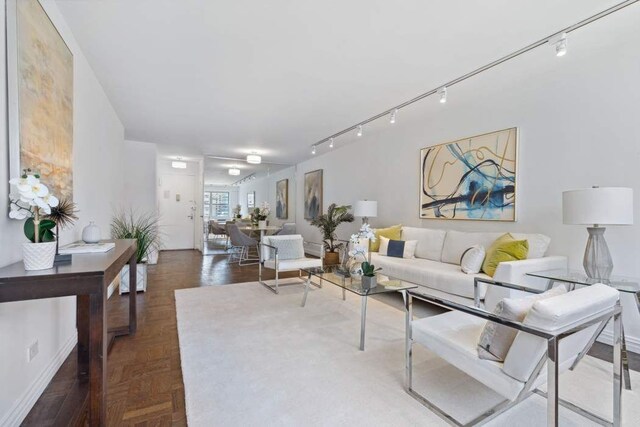 living room featuring parquet flooring and track lighting