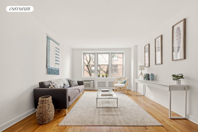 living area featuring wood finished floors, visible vents, and baseboards