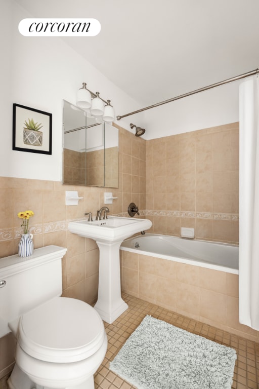 bathroom featuring shower / tub combo with curtain, tile patterned floors, toilet, and tile walls