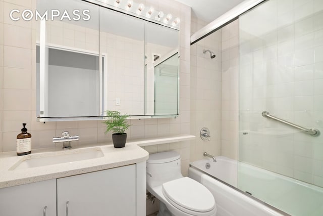 bathroom with toilet, tasteful backsplash, combined bath / shower with glass door, tile walls, and vanity