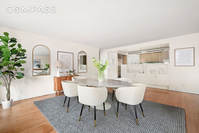 dining space with baseboards and light wood-style floors