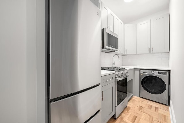 kitchen with white cabinetry, backsplash, stainless steel appliances, washer / clothes dryer, and light parquet flooring