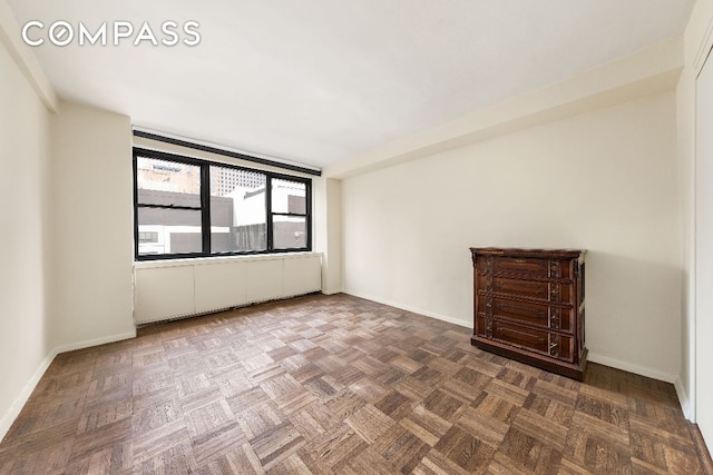 spare room featuring parquet flooring