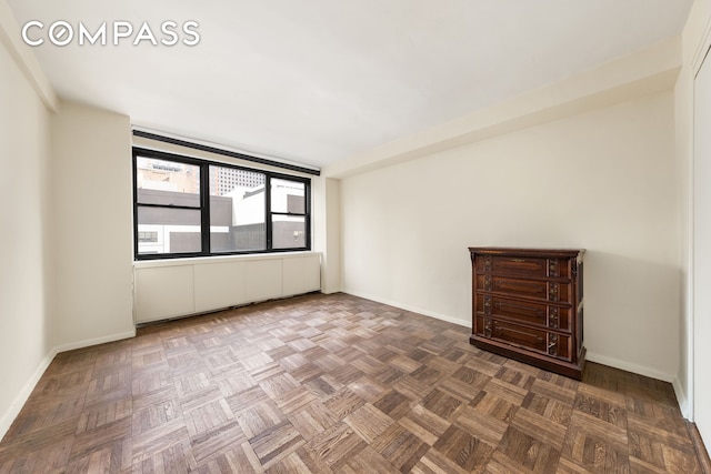 unfurnished room with baseboards