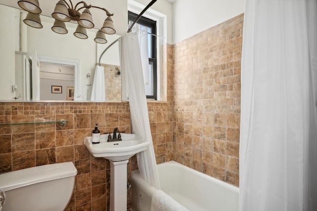 full bathroom with toilet, shower / bath combo with shower curtain, and tile walls