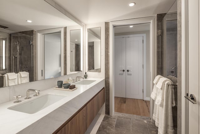 full bathroom featuring double vanity, recessed lighting, and a sink