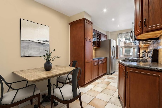 kitchen with tasteful backsplash, stainless steel appliances, and dark stone countertops