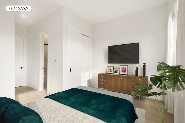 bedroom with light hardwood / wood-style floors and a closet