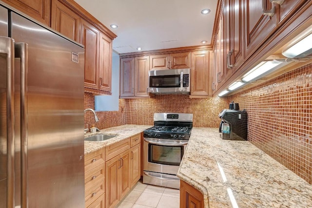 kitchen featuring tasteful backsplash, sink, light tile patterned floors, stainless steel appliances, and light stone countertops