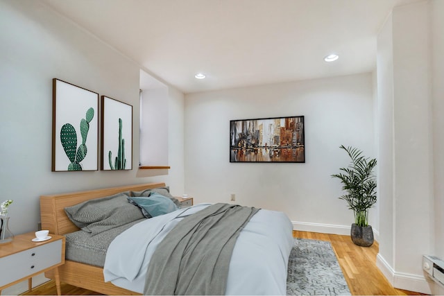 bedroom with baseboards, wood finished floors, and recessed lighting