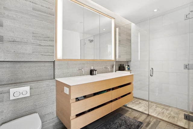 full bathroom with toilet, a stall shower, and tile walls