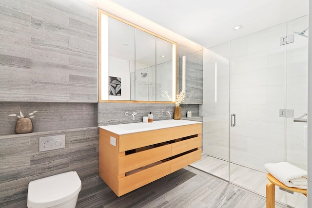 150 Rivington St Unit 5F, New York City, NY 10002 - bathroom featuring tile walls, vanity, a shower stall, toilet, and wood finished floors