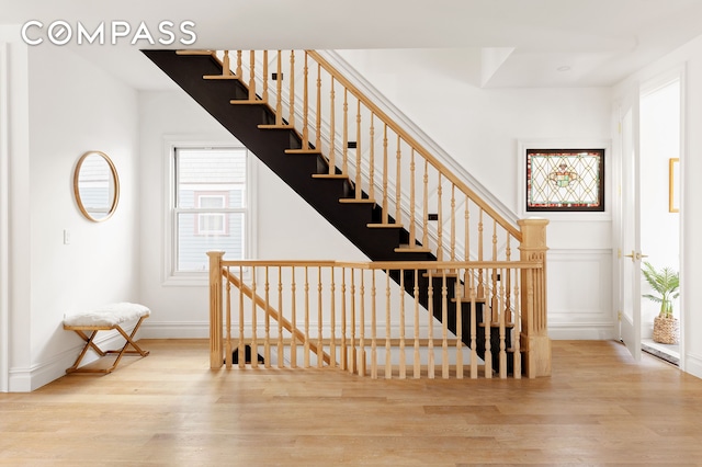 staircase featuring baseboards and wood finished floors