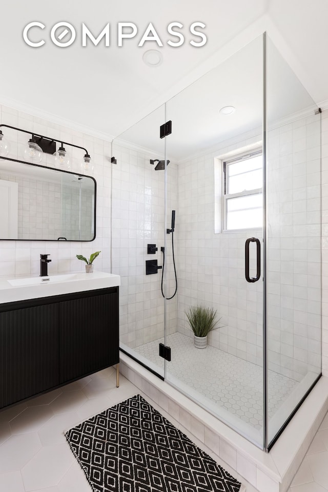full bathroom featuring crown molding, tile patterned floors, a shower stall, and vanity