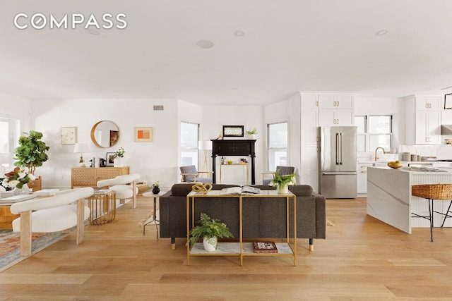 living area featuring light wood-style floors and visible vents