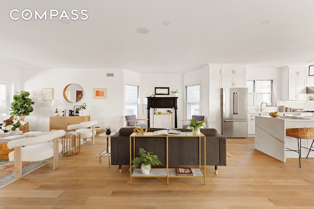 living area featuring light wood-type flooring and visible vents