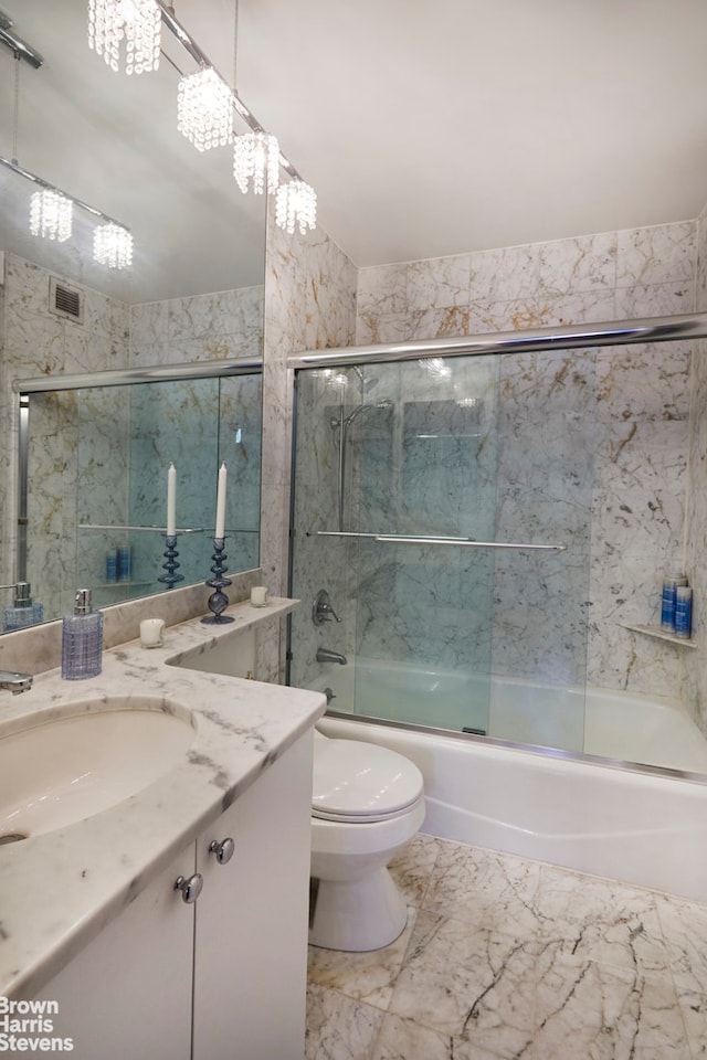 bathroom featuring visible vents, toilet, marble finish floor, combined bath / shower with glass door, and vanity