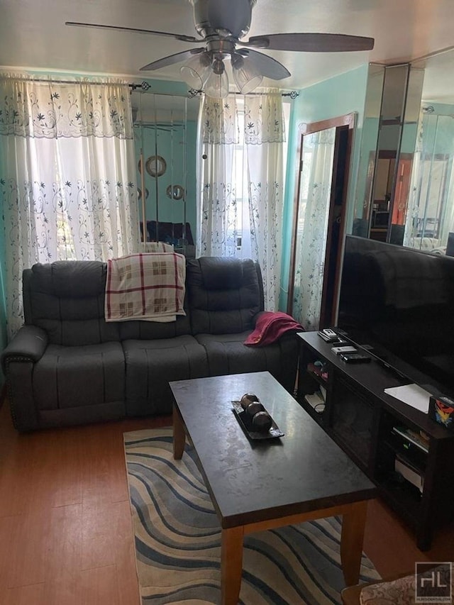 living area featuring wood finished floors and ceiling fan