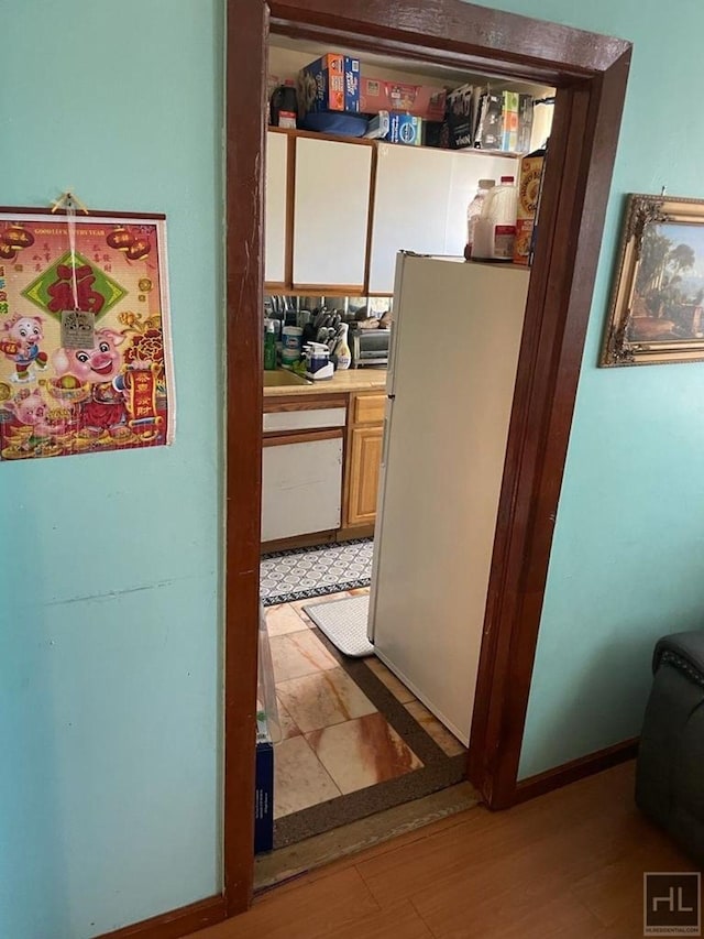 hallway with baseboards and light wood-style floors