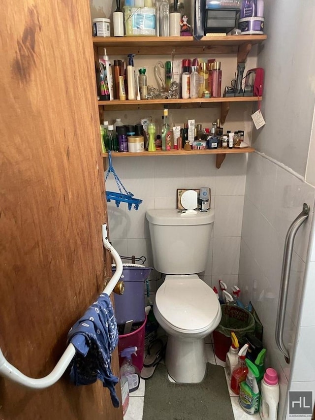 664 Osborn St Unit 1, New York City, NY 11212 - bathroom with toilet, tile walls, and wainscoting