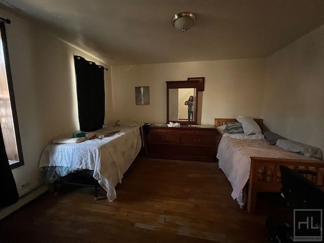 bedroom with dark wood-style flooring