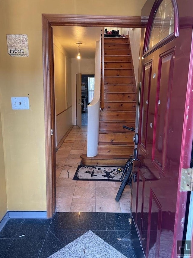 stairway featuring granite finish floor and baseboards