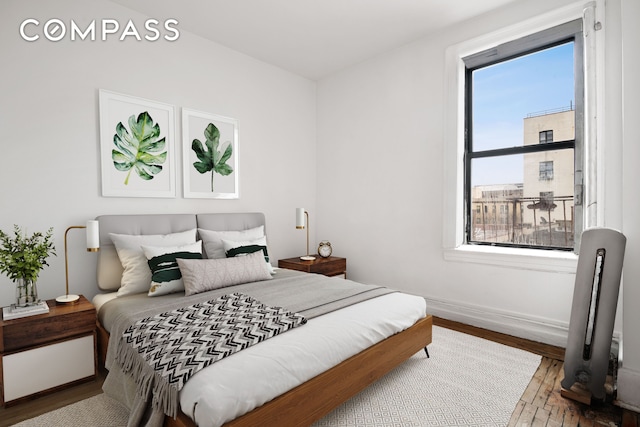 bedroom with wood finished floors and baseboards