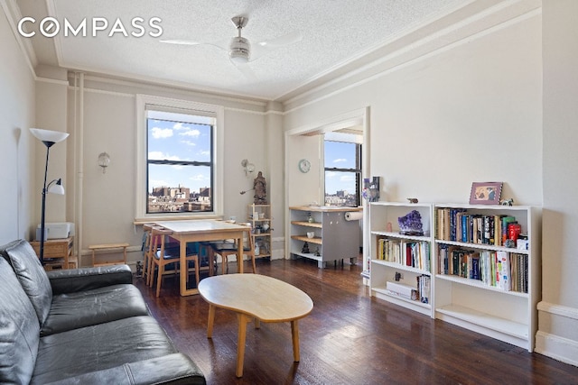 interior space with dark wood-type flooring, ceiling fan, crown molding, and a textured ceiling